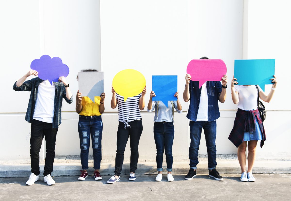 Young adult friends holding up copy space placard thought bubbles